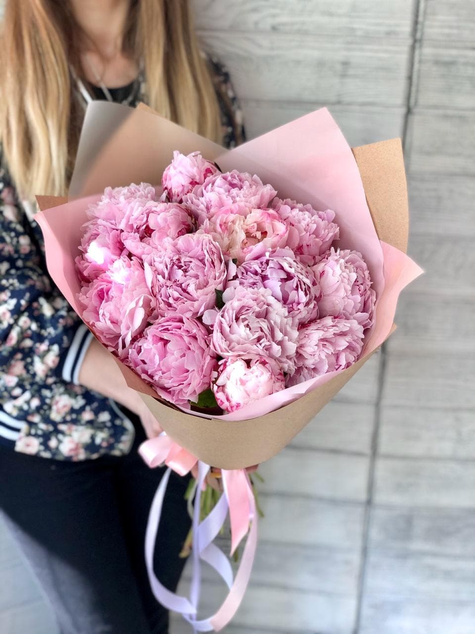 Красивый букет из 15 пионов в крафт бумаге