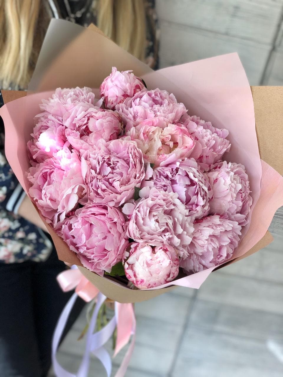 Красивый букет из 15 пионов в крафт бумаге