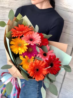 Весенний букет из 9 гербер в крафте с зеленью